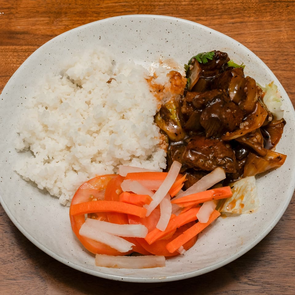 Ooh Pho's Vietnamese dish with white rice, dark sauced meat, and pickled carrots and daikon.